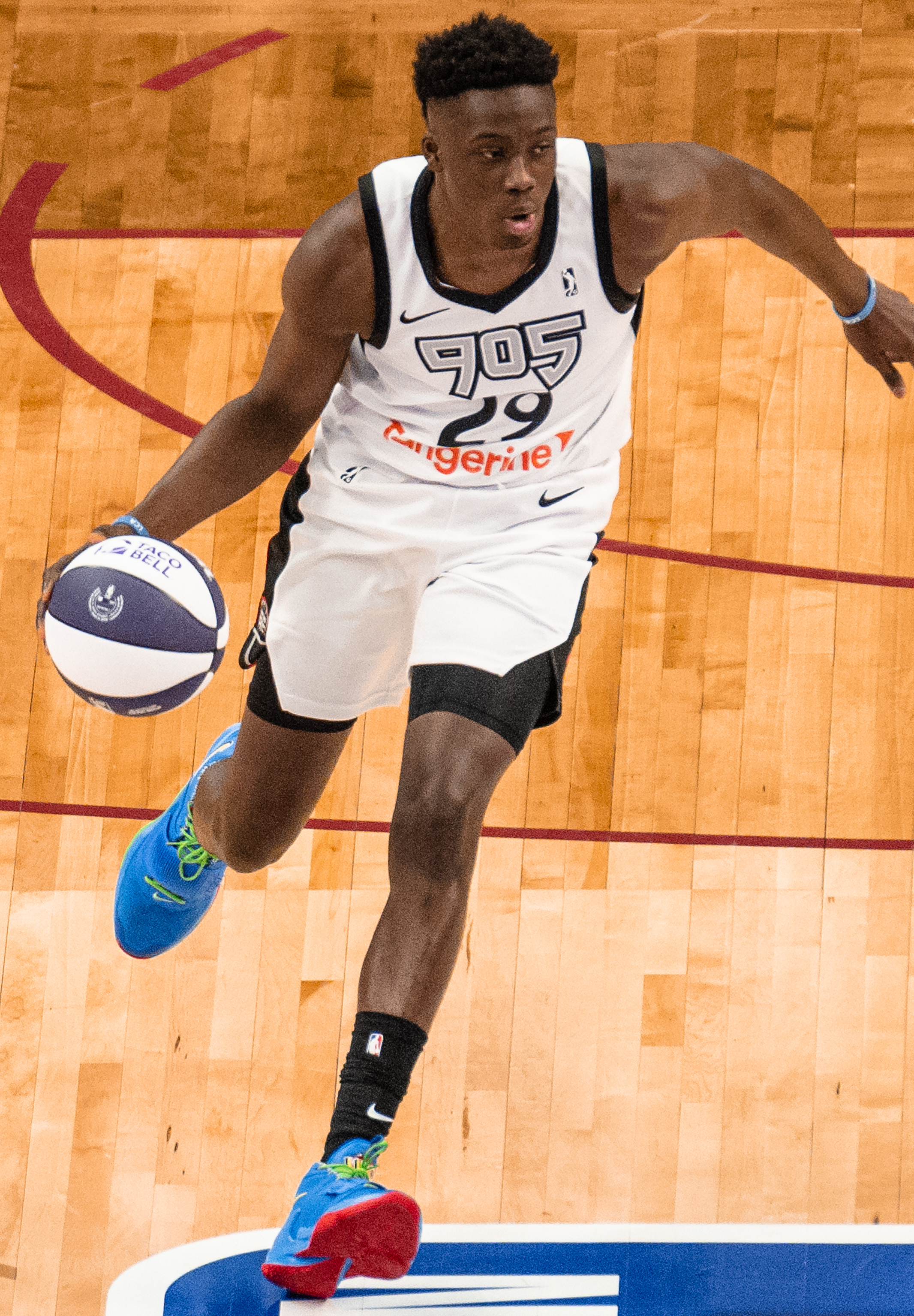 Alex Antetokounmpo在篮球场上运球